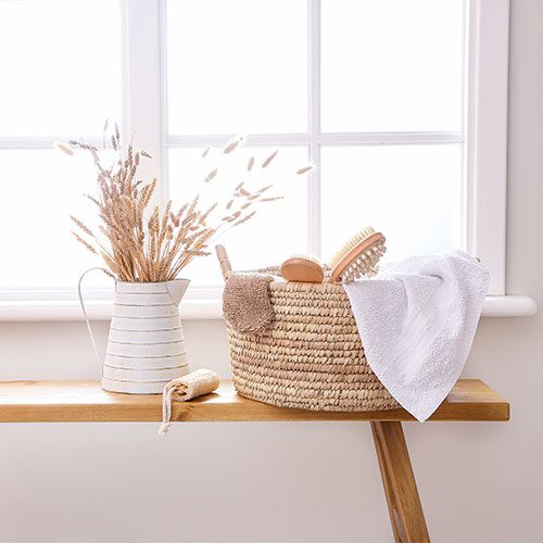 Basket filled with bathroom linen and bath decor accessories