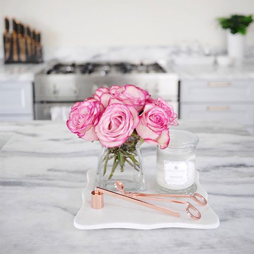 Stylish candles and cloches decor items on kitchen island
